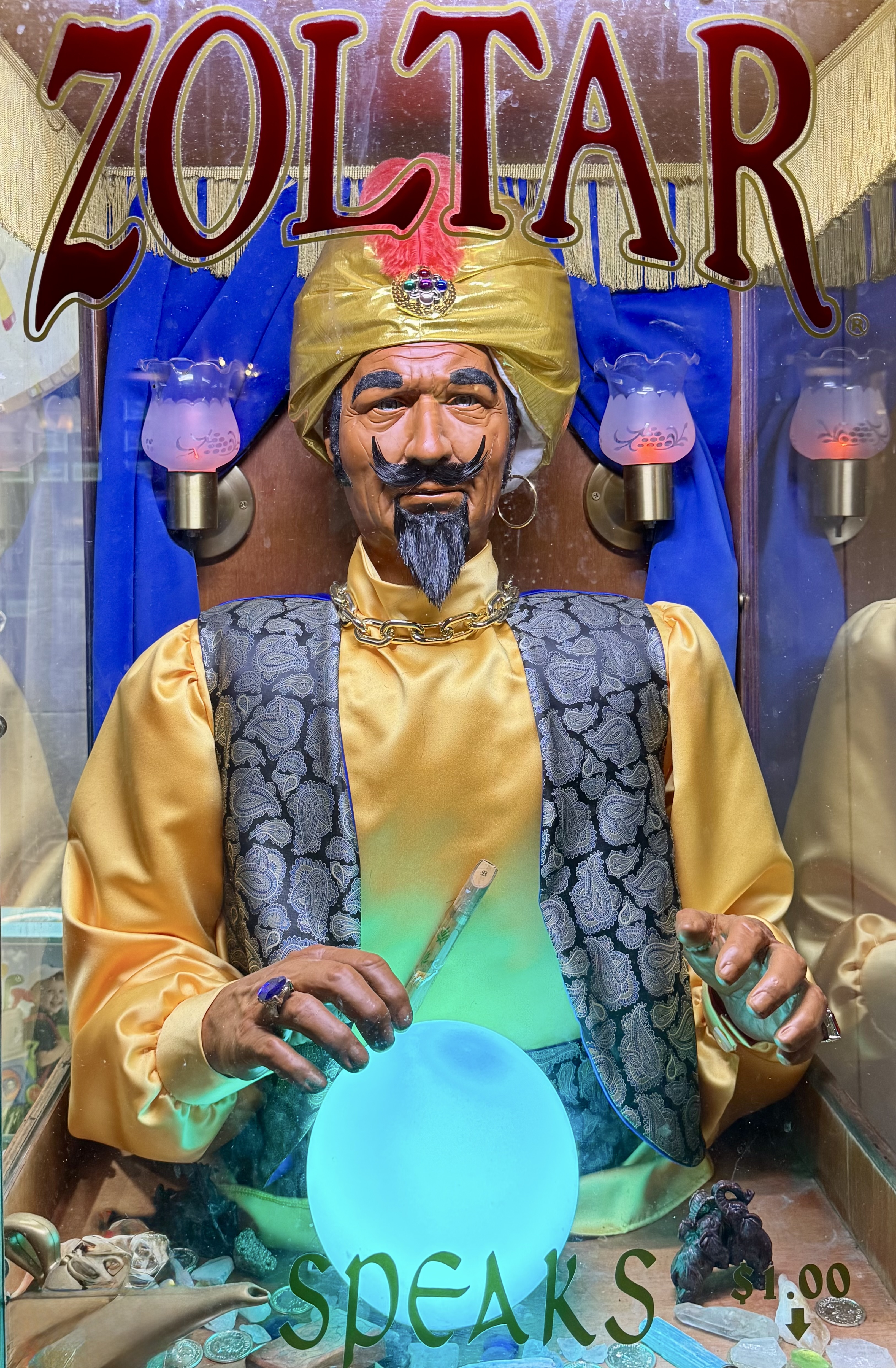 A vintage Zoltar fortune-telling machine, turbaned figure with a glowing crystal ball